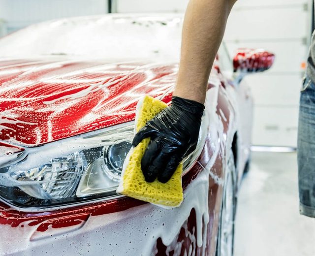 Hand washing a car with a wash mitt